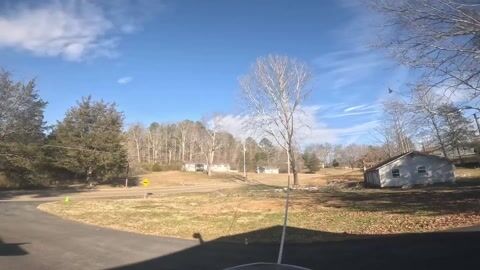 GoPro footage of the work area in winter, bare hardwoods along the drive with a cone marking the drop zone