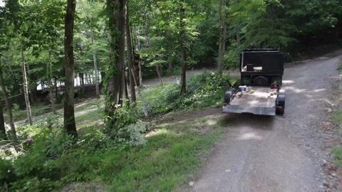 Cut brush and ground protection along the wooded drive, the truck loaded alongside