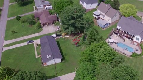 Drone footage looking down over the work area as the crew clears cut brush toward the chipper