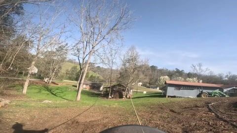 GoPro footage of the winter work site, bare hardwoods above cleared ground with the tractor working beyond