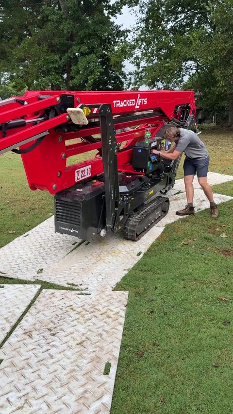 Moving the lift onto the customer's yard, we use the ground protection mats to protect the lawn from scuff marks and tearing from the tracks of the lift.